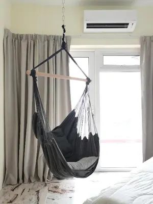 a hammock hanging in a bedroom next to a window at Ampang Hilir KL City Boutique Residence in Kuala Lumpur
