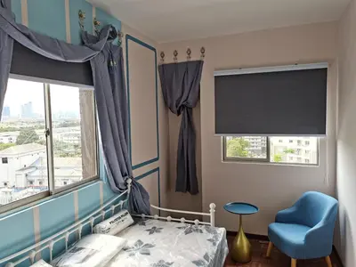 a bedroom with a bed and a chair and windows at Ampang Hilir KL City Boutique Residence in Kuala Lumpur