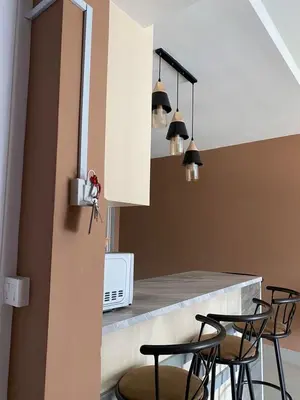 a kitchen with black chairs and a counter top at M Centura Sentul in Kuala Lumpur