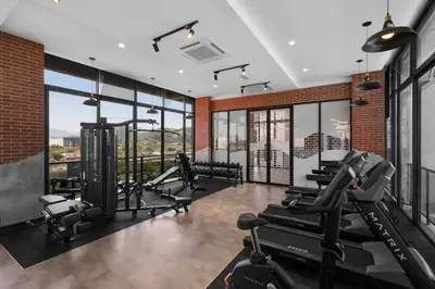 a gym with treadmills and cardio machines in a room with windows at The Harmony at Astoria Ampang - Mountain View in Kuala Lumpur