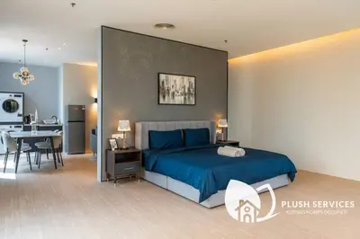 a bedroom with a blue bed and a dining room at Bangsar Trade Centre in Kuala Lumpur