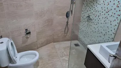 a bathroom with a shower and a toilet and a sink at Hostel At Regalia Sky Pool in Kuala Lumpur