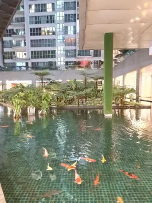 a pond in a building with fish in it at Hostel At Regalia Sky Pool in Kuala Lumpur