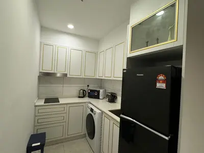 a kitchen with white cabinets and a black refrigerator at AXON SUITE aT BUKIT BINTANG KL near Pavillion in Kuala Lumpur