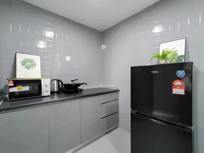 a kitchen with a black refrigerator and a microwave at Plaza Berjaya By Manhattan Group in Kuala Lumpur