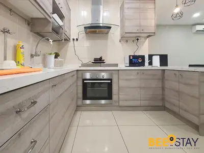 a kitchen with white cabinets and a stove at Rafflesia Condominium Sentul by Beestay in Kuala Lumpur