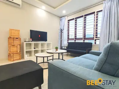 a living room with two blue couches and a tv at Rafflesia Condominium Sentul by Beestay in Kuala Lumpur