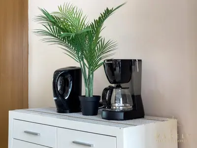a plant sitting on a counter next to a coffee maker at Soho Suites KLCC by Wakely Kuala Lumpur in Kuala Lumpur