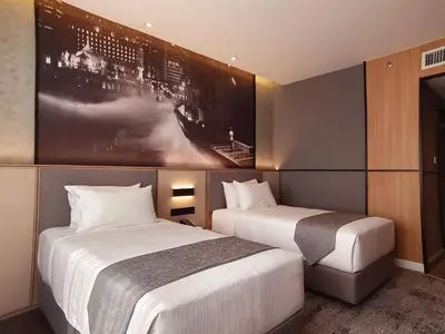 two beds in a hotel room with a picture on the wall at Hotel Royal Signature in Kuala Lumpur