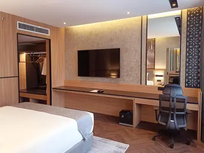 a bedroom with a bed and a desk with a television at Hotel Royal Signature in Kuala Lumpur