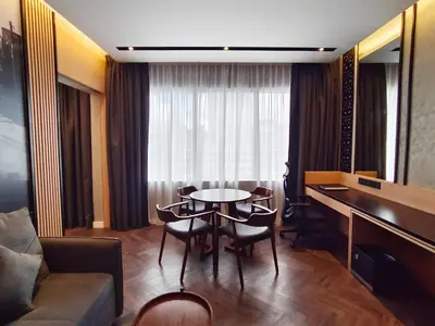 a living room with a table and chairs and a couch at Hotel Royal Signature in Kuala Lumpur