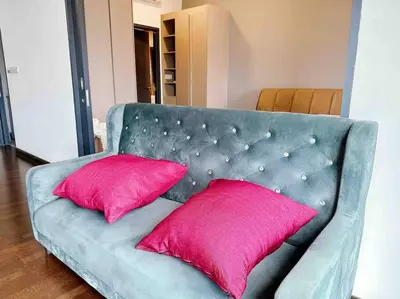 a blue couch with two pink pillows on it at Sunway Velocity Suite link velocity mall in Kuala Lumpur
