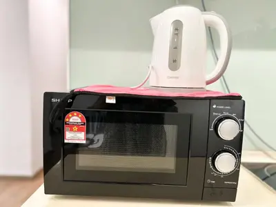 a microwave with a white kettle on top of it at Setapak Central Signature Suites by Manhattan Group in Kuala Lumpur