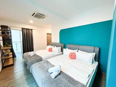 two beds in a room with a blue wall at Setapak Central Signature Suites by Manhattan Group in Kuala Lumpur