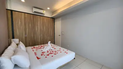 a room with a bed with red flowers on it at Balcony Unit @ Robertson Residence 18f in Kuala Lumpur