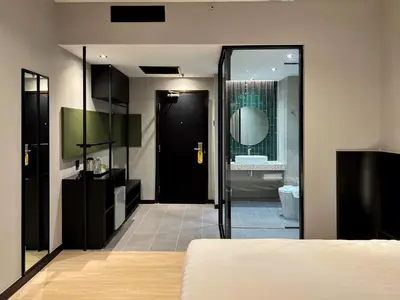 a bedroom with a black door leading to a bathroom at Crystal Crown Hotel Kuala Lumpur in Kuala Lumpur