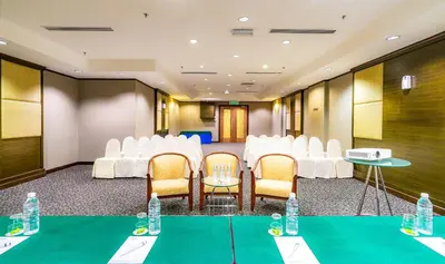 a conference room with white chairs and tables and water bottles at Crystal Crown Hotel Kuala Lumpur in Kuala Lumpur