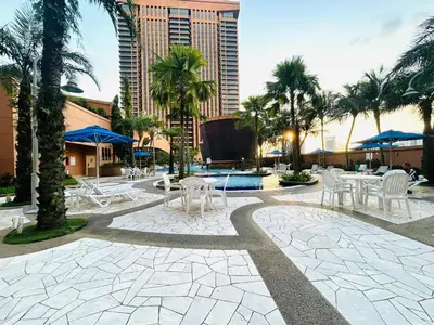 a courtyard with tables and chairs and palm trees at APARTMENT by Times Square KL in Kuala Lumpur