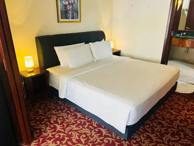 a bedroom with a large bed with white sheets and pillows at APARTMENT by Times Square KL in Kuala Lumpur