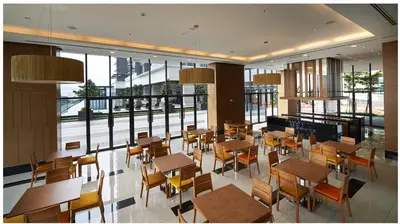 a restaurant with wooden tables and chairs and windows at The Elements @ Ampang in Kuala Lumpur
