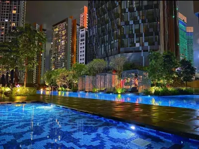 a large swimming pool in a city at night at Star residance at Klcc - Two bedrooms with twin towers view in Kuala Lumpur