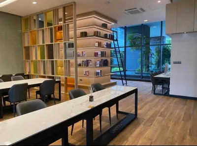 a room with tables and chairs and a book shelf at Star residance at Klcc - Two bedrooms with twin towers view in Kuala Lumpur