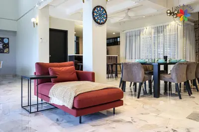 a dining room with a red chair and a table at KL Townhouse Villa by LilyandLoft in Kuala Lumpur
