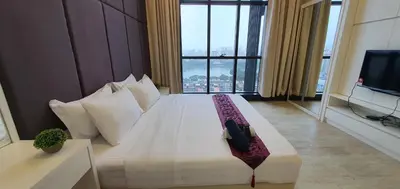 a hotel room with a bed with a large window at Panoramic KLCC Lake view, M CITY Jalan Ampang in Kuala Lumpur