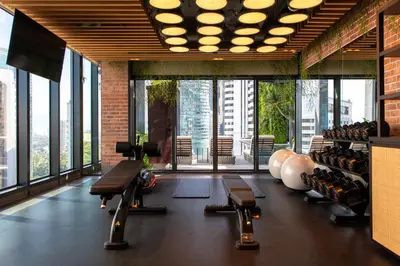 a gym with a lot of windows and a bunch of machines at Hotel Indigo Kuala Lumpur on the Park by IHG in Kuala Lumpur
