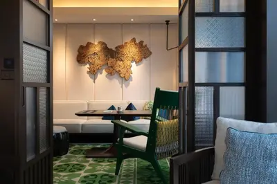 a dining room with a table and a green chair at Hotel Indigo Kuala Lumpur on the Park by IHG in Kuala Lumpur