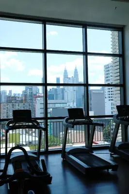 a gym with three treadmills in front of a large window at Chambers Residence by FANTASTIC in Kuala Lumpur