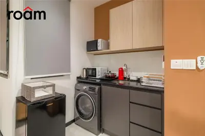 a small kitchen with a washing machine and a washer at Neu Suites Residence, Embassy Row in Kuala Lumpur