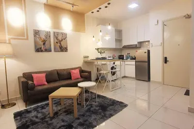 a living room with a couch and a kitchen at Arte Mont Kiara in Kuala Lumpur