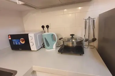 a kitchen counter with a stove and a toaster at Arte Mont Kiara in Kuala Lumpur