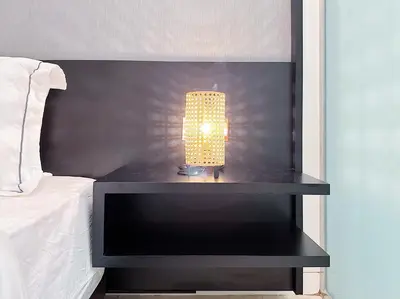 a lamp sitting on a table next to a bed at Tropicana The Residence Hermes Suite with KLCC View in Kuala Lumpur