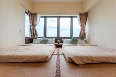 two beds in a room with a large window at Penthouse Sky Jacuzzi At KLCC in Kuala Lumpur
