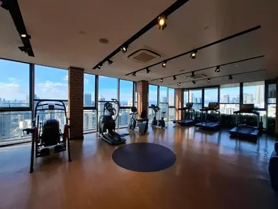 a gym with exercise equipment in a building with windows at Ceylonz Suites By ANA MALAYSIA in Kuala Lumpur