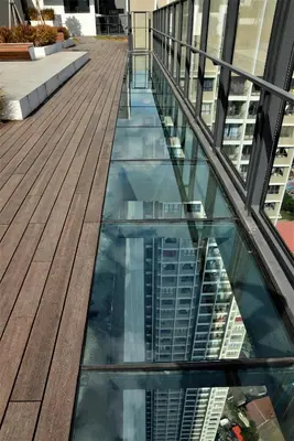 a glass floor in a building with a reflection in the water at Suasana Homestay Kewingston Platz in Kuala Lumpur