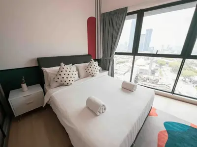 a bedroom with a white bed with a large window at Continew Residence Cozy Suite by GUESTONIC in Kuala Lumpur