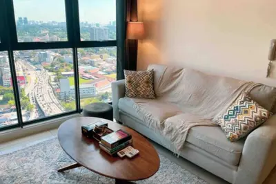 a living room with a couch and a table at Continew Residence Cozy Suite by GUESTONIC in Kuala Lumpur