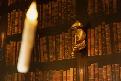 a candle in front of a wall of books at Wizarding Residence near KLCC link LRT & Mall in Kuala Lumpur