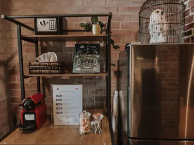 a kitchen with a refrigerator next to a brick wall at Wizarding Residence near KLCC link LRT & Mall in Kuala Lumpur