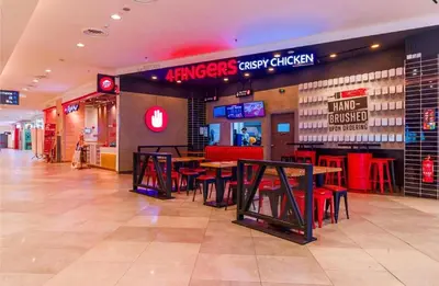 a fast food restaurant with tables and red chairs at Wizarding Residence near KLCC link LRT & Mall in Kuala Lumpur
