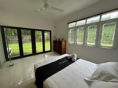 a bedroom with a large bed and large windows at Bungalow with Pool Karaoke PJ 12 in Petaling Jaya