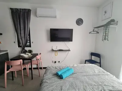 a bedroom with a bed and a table and a tv at Contemporary 2R2B Studio 10 minutes from KLCC in Kuala Lumpur