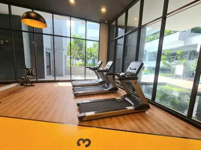 a row of treadmills in a gym with windows at Contemporary 2R2B Studio 10 minutes from KLCC in Kuala Lumpur