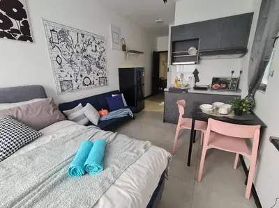 a room with a bed and a table and a kitchen at Contemporary 2R2B Studio 10 minutes from KLCC in Kuala Lumpur
