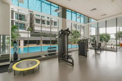 a gym with a swimming pool in a building at OOAK SUITES AT MONT KIARA KUALA LUMPUR in Kuala Lumpur