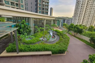 an apartment building with a garden and a fountain at OOAK SUITES AT MONT KIARA KUALA LUMPUR in Kuala Lumpur