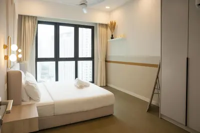 a bedroom with a bed and a large window at OOAK SUITES AT MONT KIARA KUALA LUMPUR in Kuala Lumpur